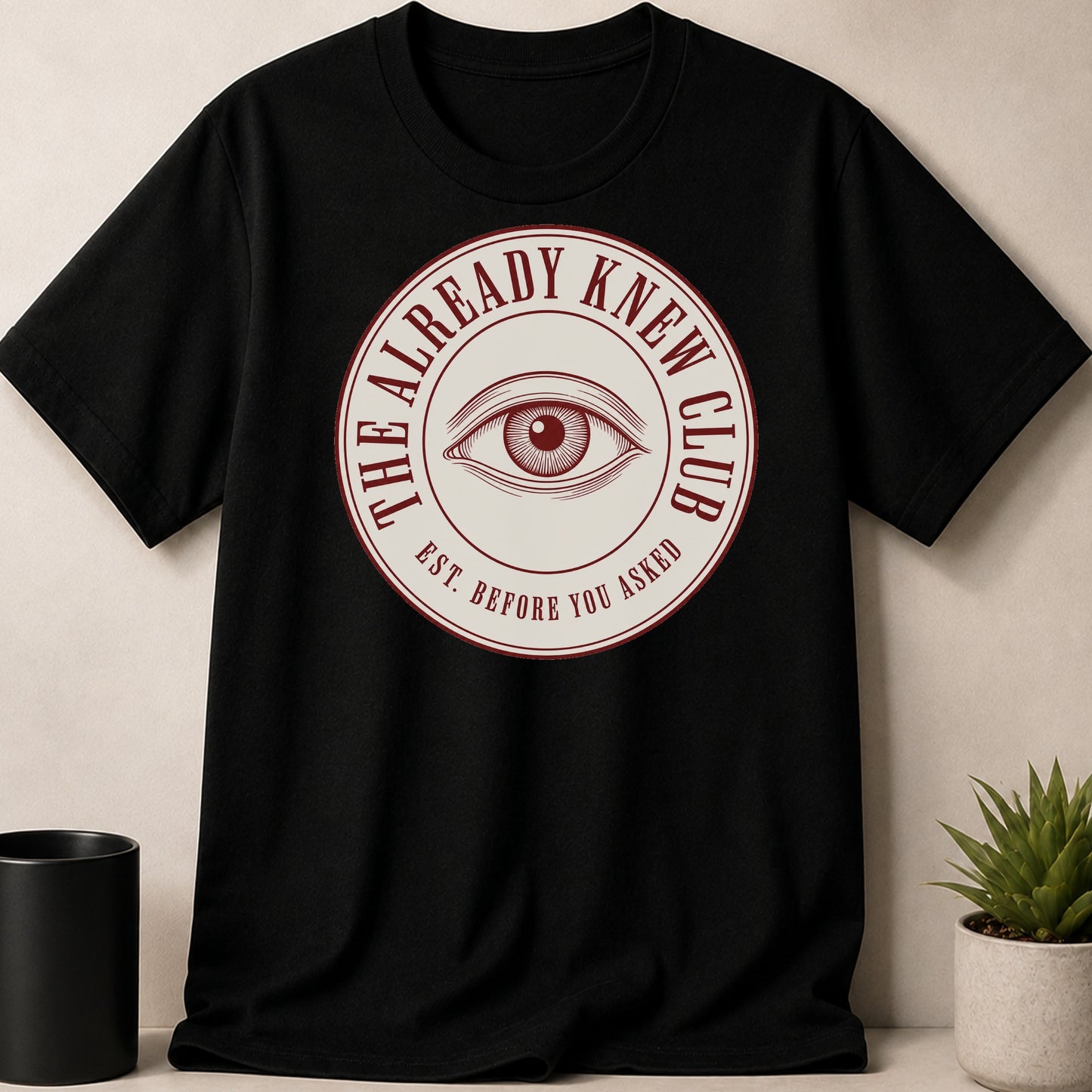 Black t-shirt with circular emblem featuring an eye and text.