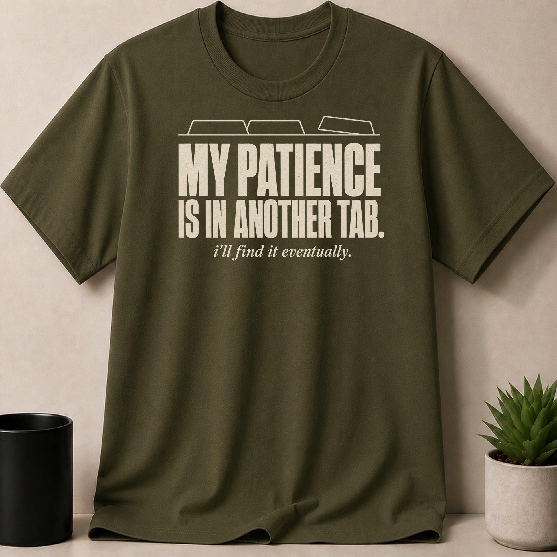 Green t-shirt with cream text "MY PATIENCE IS IN ANOTHER TAB. i'll find it eventually."