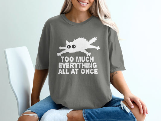 Grey t-shirt with a white cartoon cat and text "TOO MUCH EVERYTHING ALL AT ONCE".