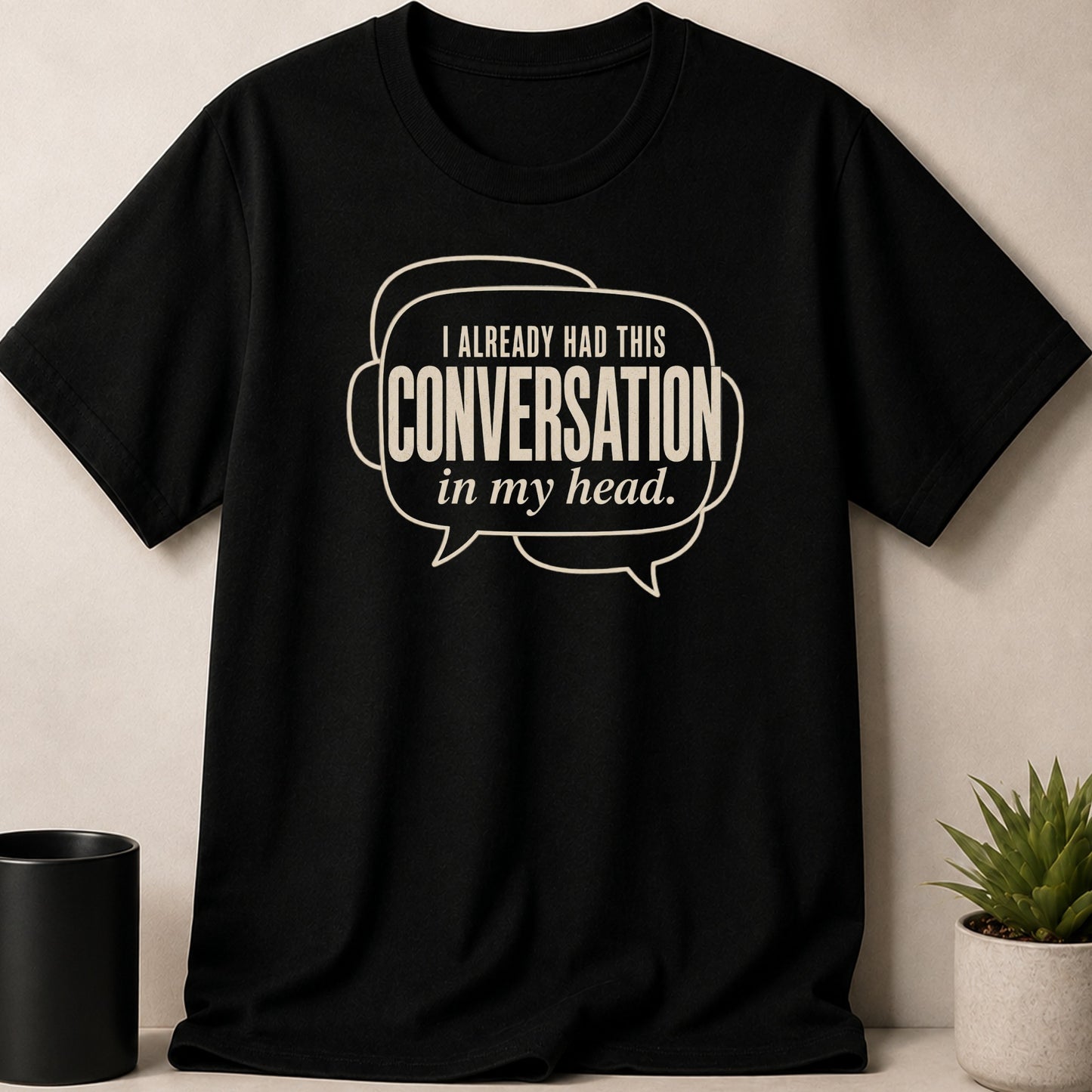 Black t-shirt with off-white text reading "I ALREADY HAD THIS CONVERSATION in my head."