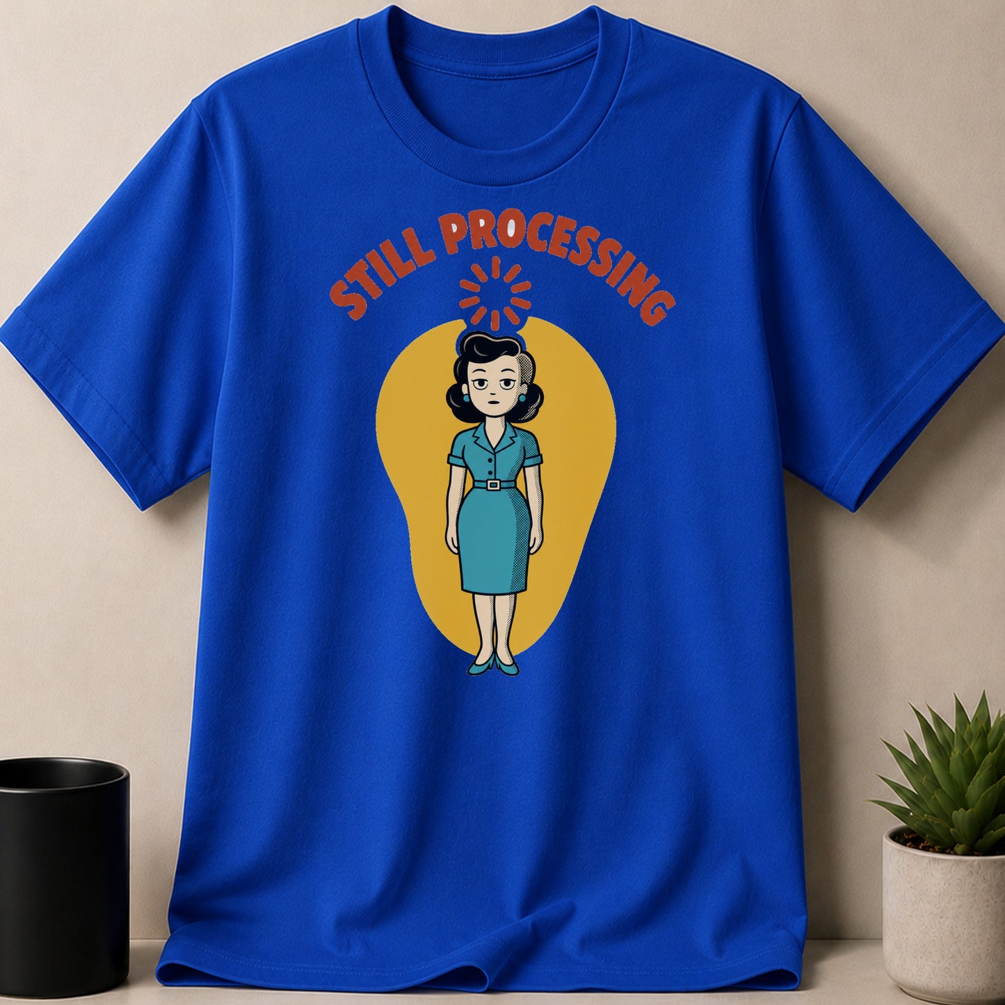 Blue t-shirt with cartoon woman and text "STILL PROCESSING".