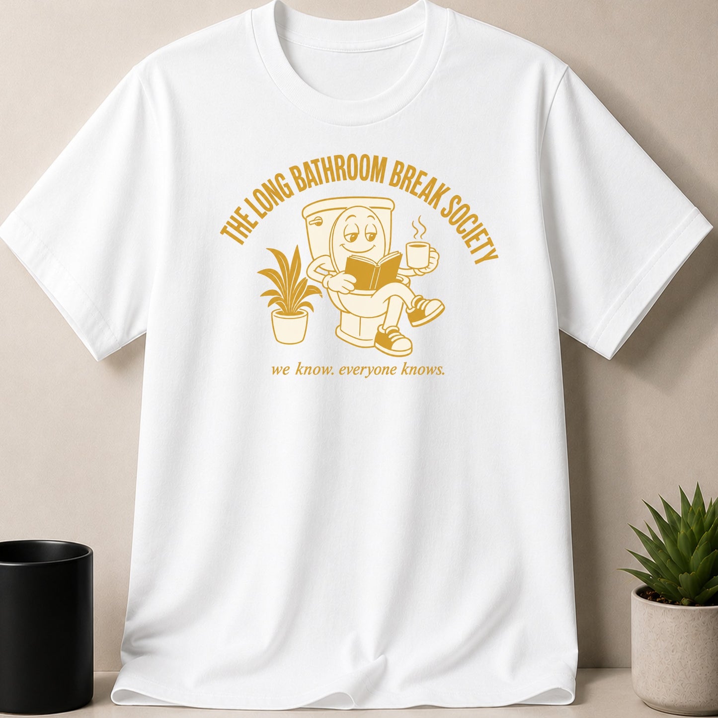 White t-shirt with graphic of a toilet reading a book and drinking coffee.