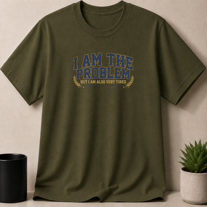 Olive green t-shirt with blue and yellow text: "I AM THE PROBLEM BUT I AM ALSO VERY TIRED."
