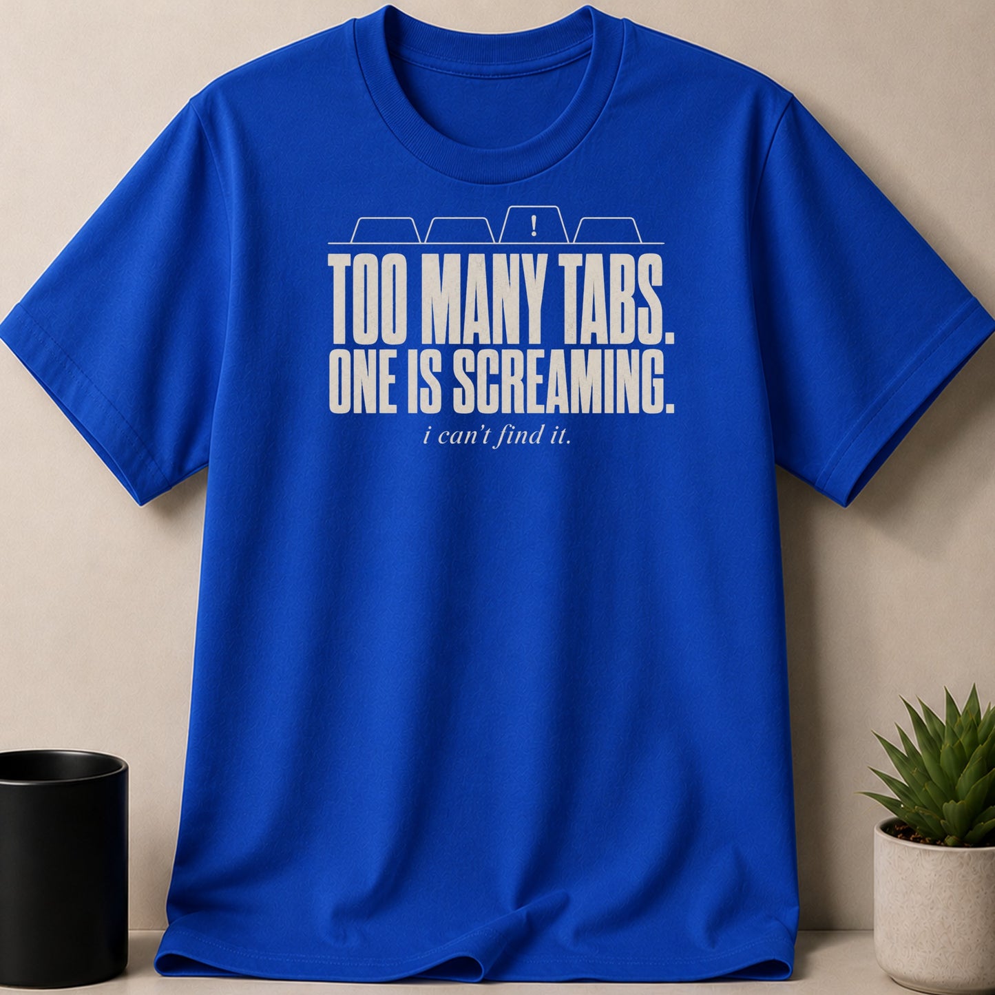 Royal blue t-shirt with white text: "TOO MANY TABS. ONE IS SCREAMING. i can't find it."