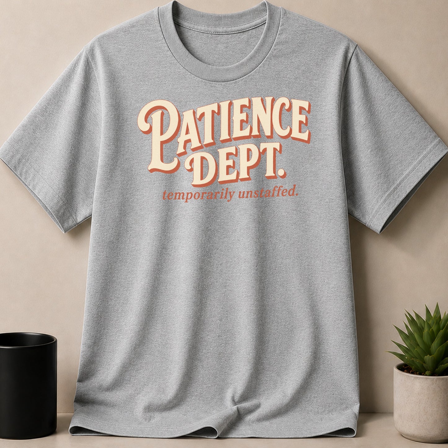 Grey t-shirt with "Patience Dept. temporarily unstaffed." text.