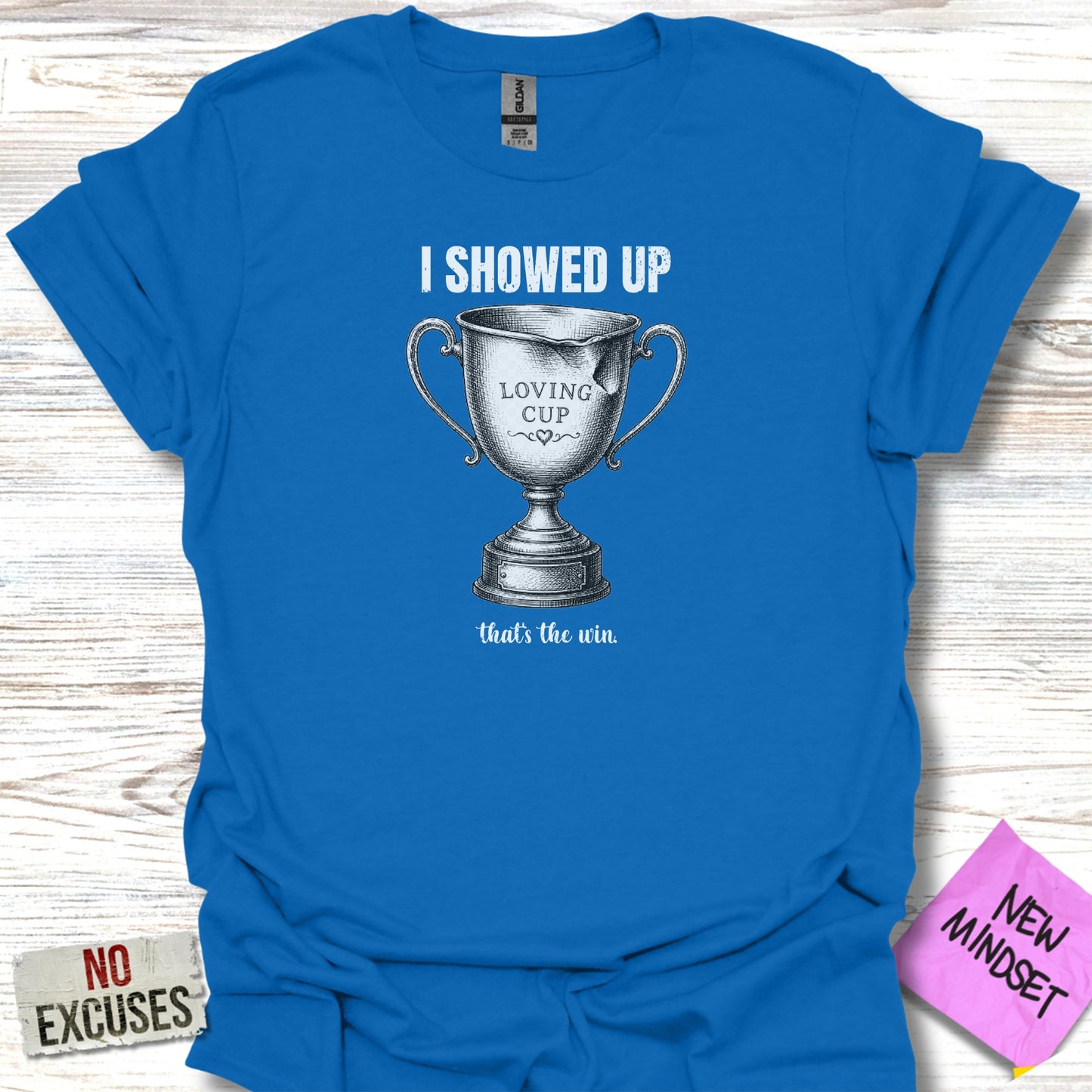Blue t-shirt with "I SHOWED UP LOVING CUP that's the win" text and trophy graphic.