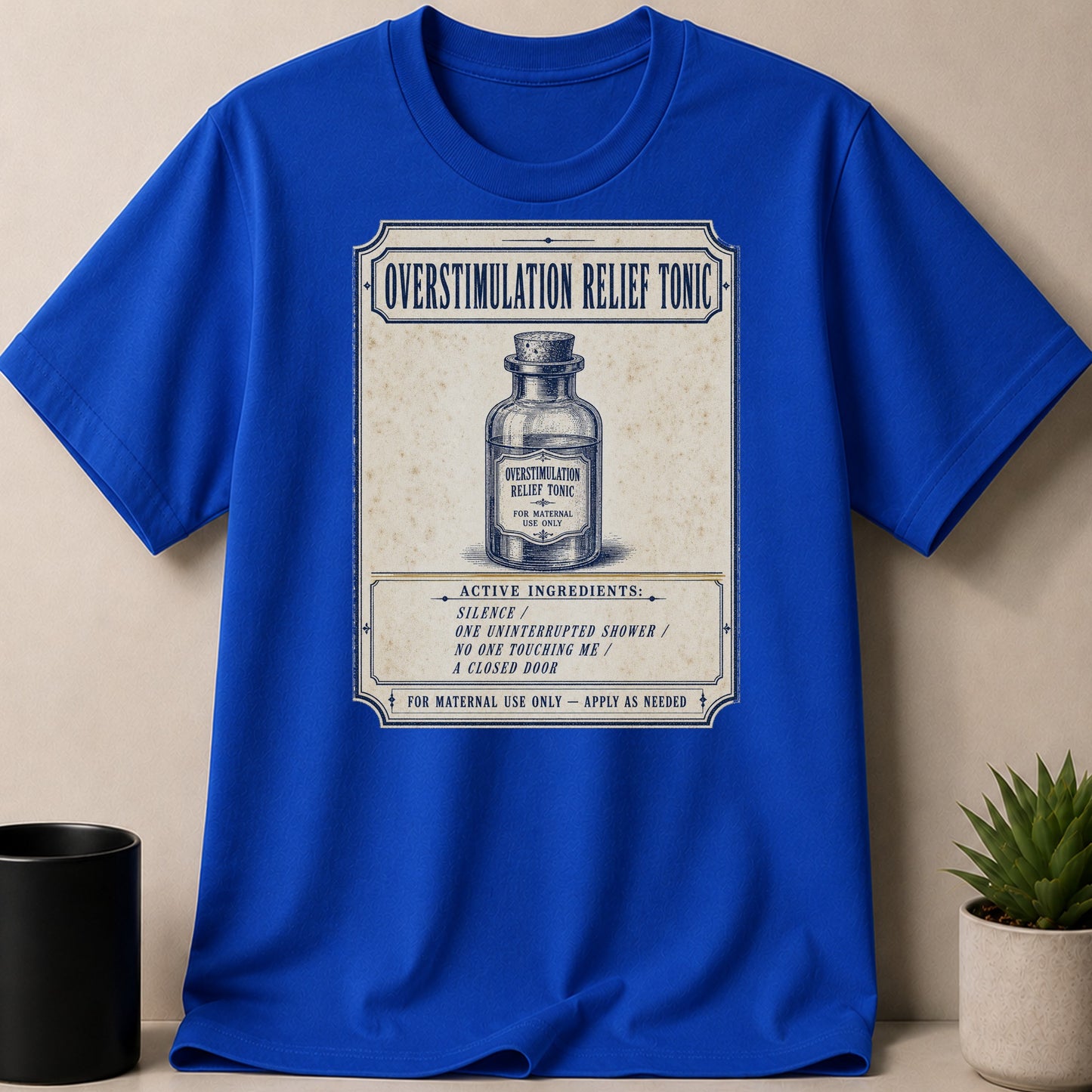 Blue t-shirt with "Overstimulation Relief Tonic" design featuring a bottle and ingredients list.