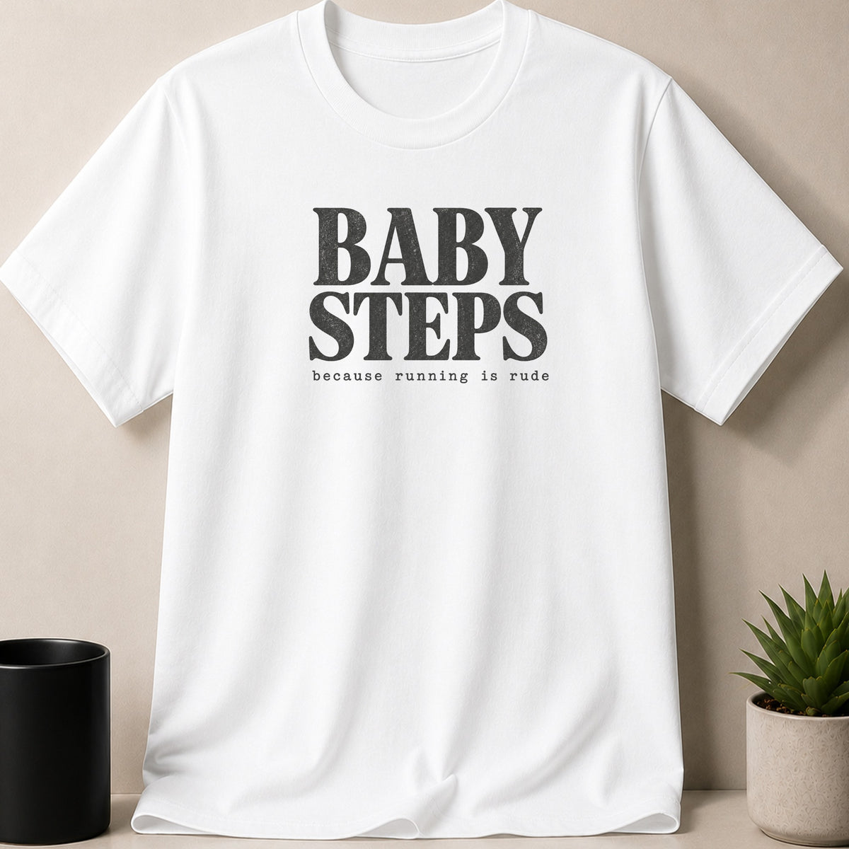 White t-shirt with black text "BABY STEPS because running is rude".