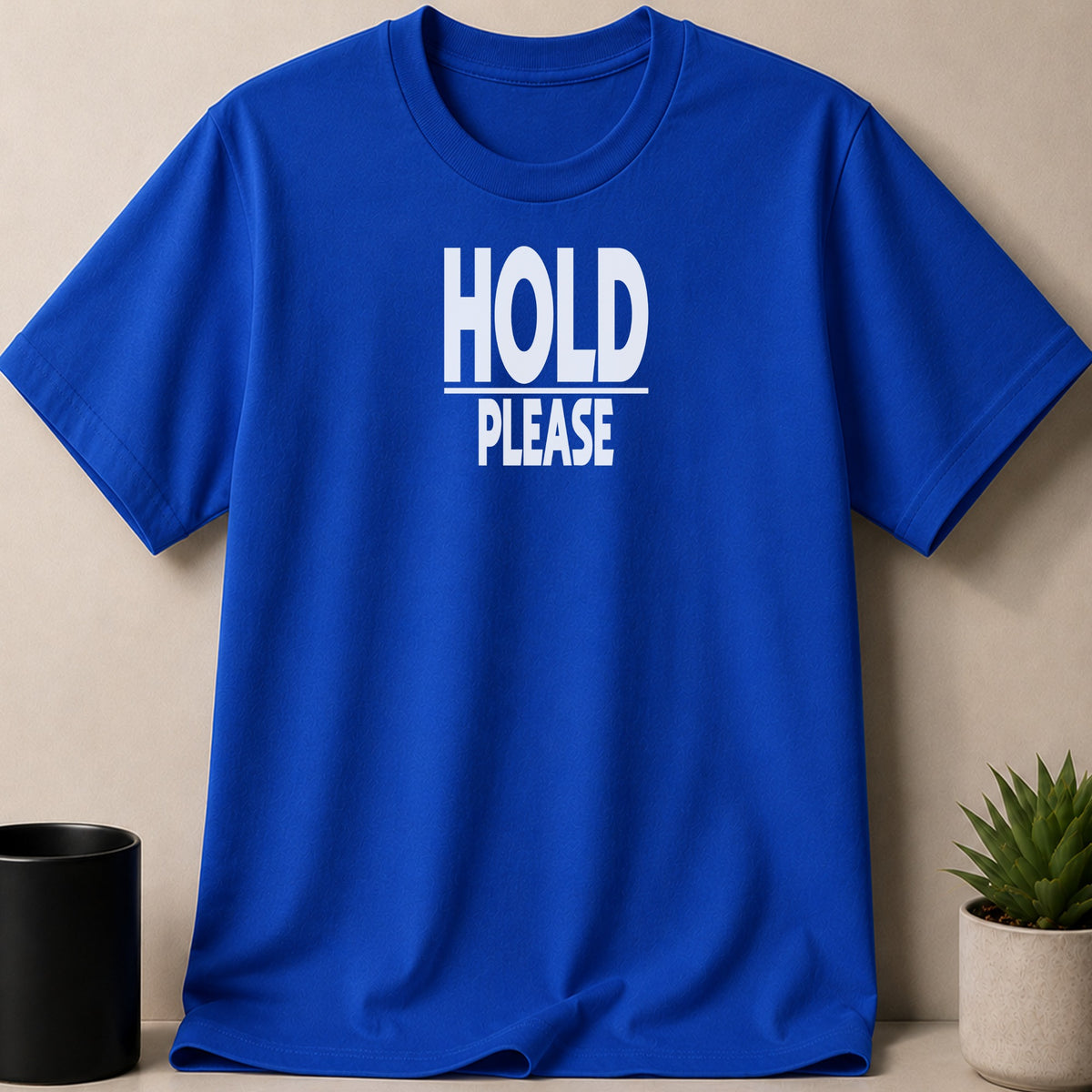 Blue t-shirt with white text that reads "HOLD PLEASE".