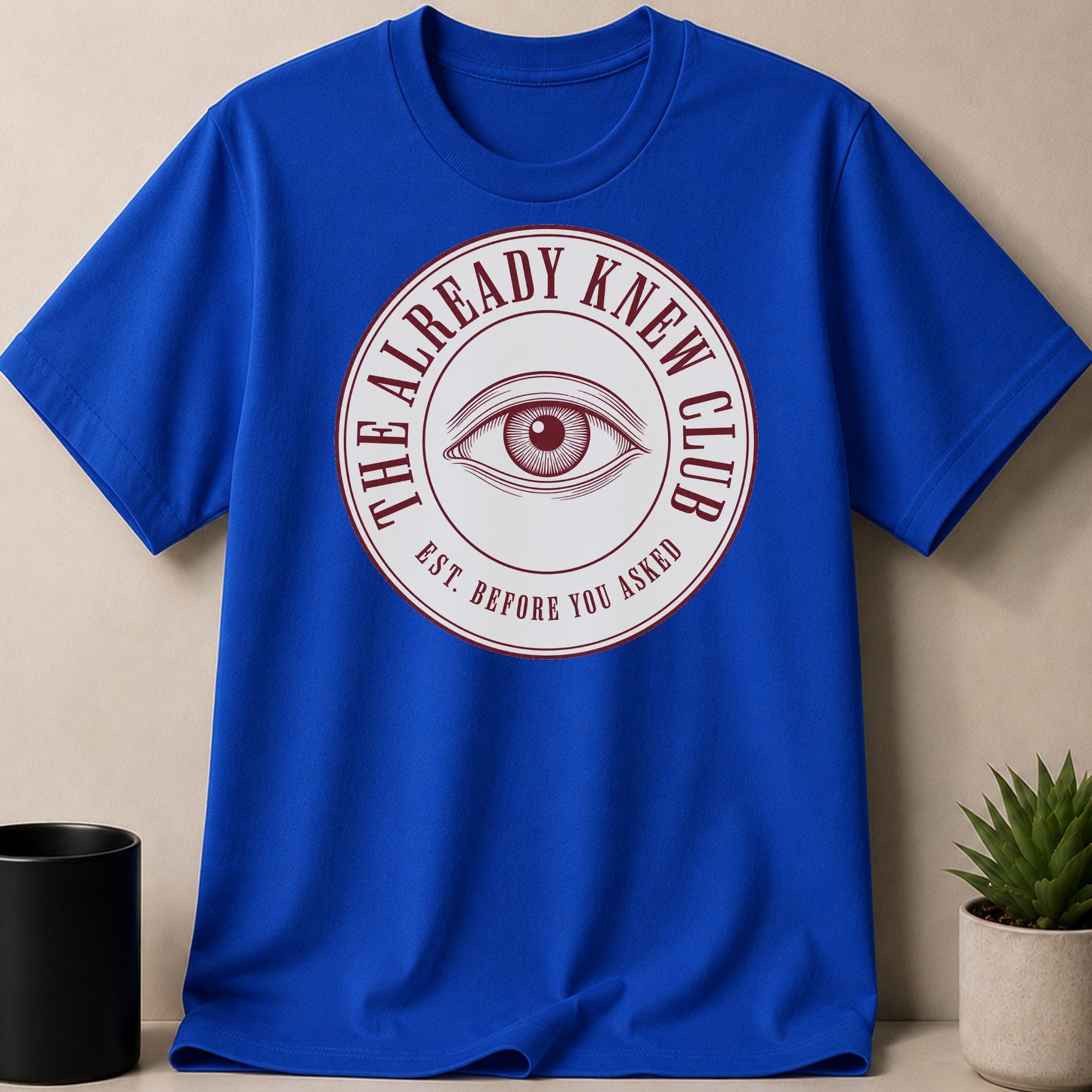 Blue t-shirt with a circular graphic of an eye and text.