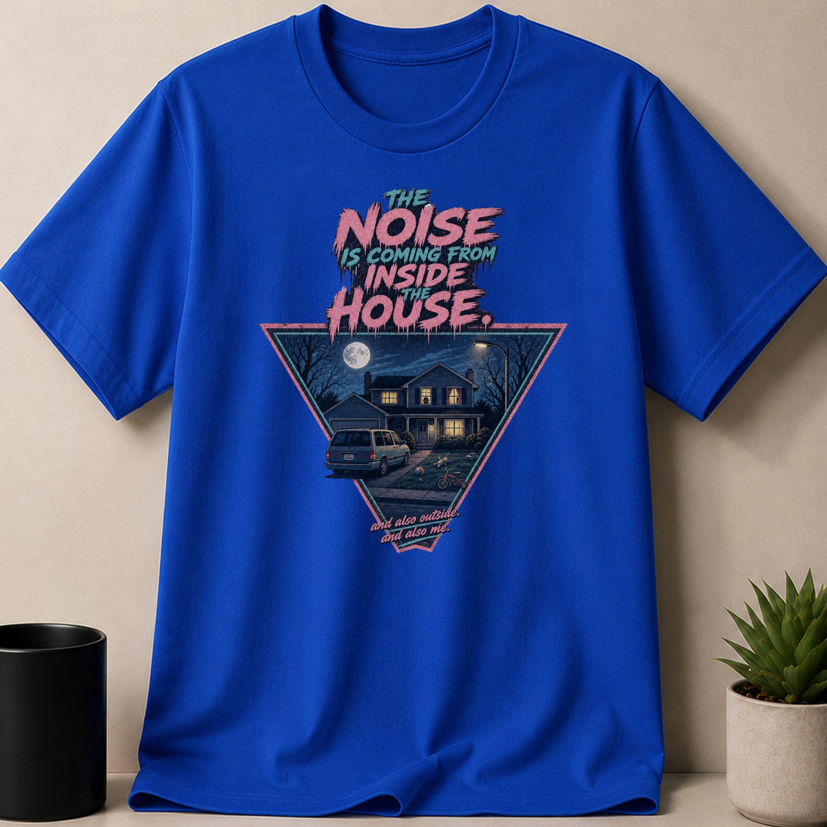Blue t-shirt with a triangle graphic of a house at night with text.