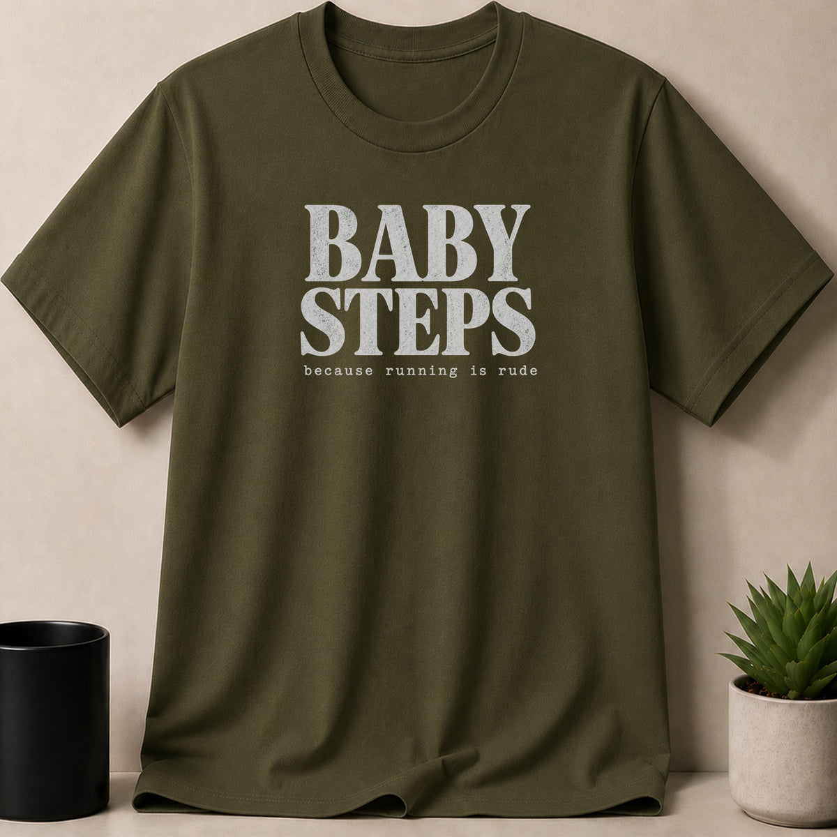 Olive green t-shirt with "BABY STEPS" and "because running is rude" text.