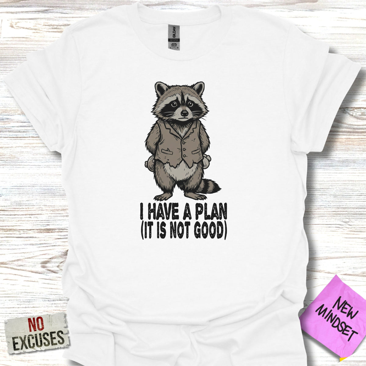 White t-shirt with a raccoon in a suit, saying "I HAVE A PLAN (IT IS NOT GOOD)".