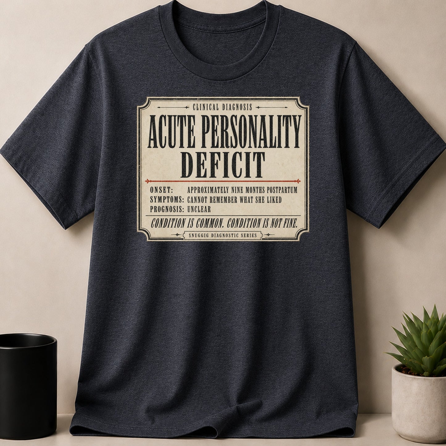 Dark grey t-shirt with "Acute Personality Deficit" diagnostic print.