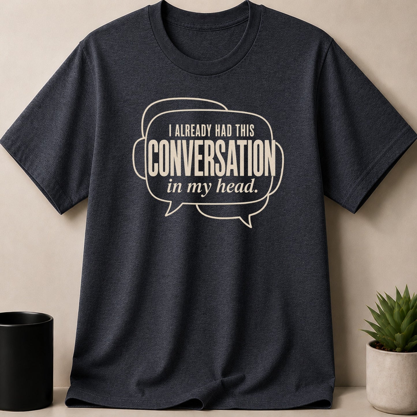 Dark heather t-shirt with cream text saying "I ALREADY HAD THIS CONVERSATION in my head."