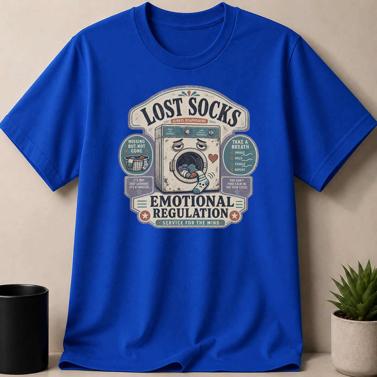 Blue t-shirt with distressed graphic of a washing machine and text about emotional regulation.