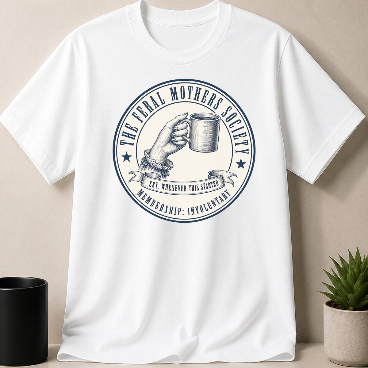 White t-shirt with a circular logo featuring a hand holding a mug and text.