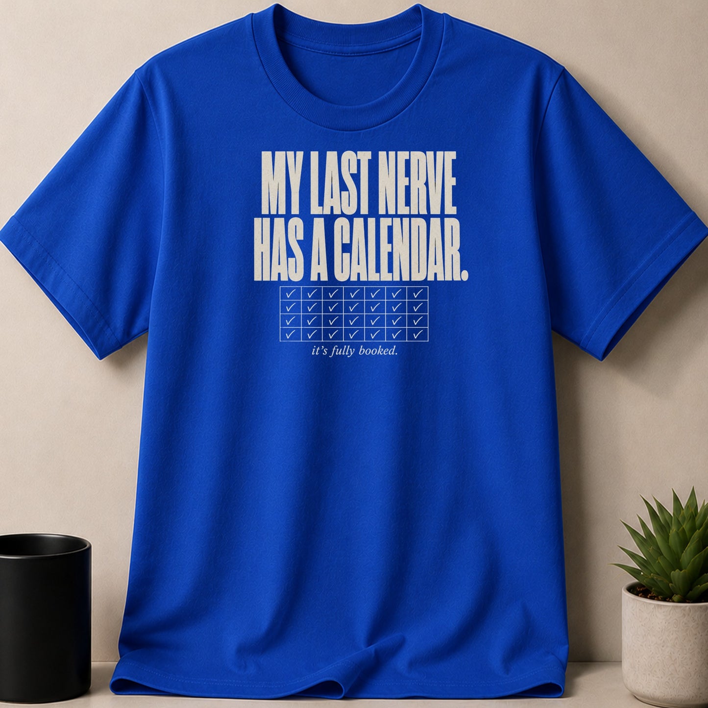 Blue t-shirt with white text: "MY LAST NERVE HAS A CALENDAR. it's fully booked."