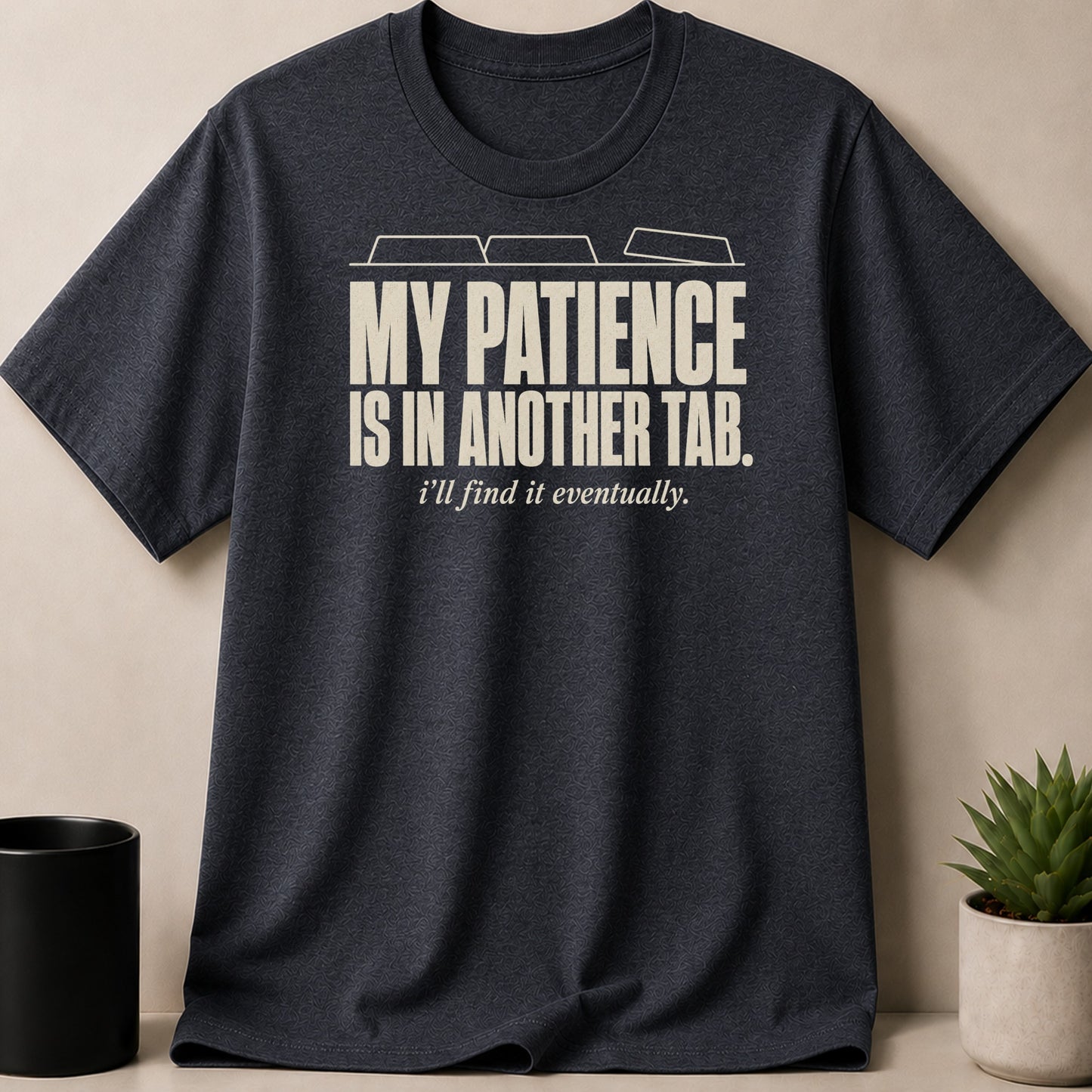 Dark grey t-shirt with cream text reading "MY PATIENCE IS IN ANOTHER TAB. i'll find it eventually."