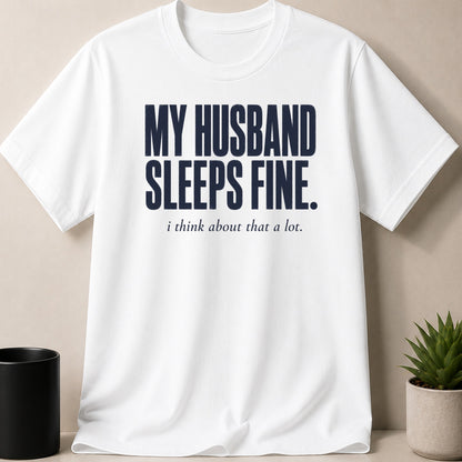 White t-shirt with navy text "MY HUSBAND SLEEPS FINE. i think about that a lot."