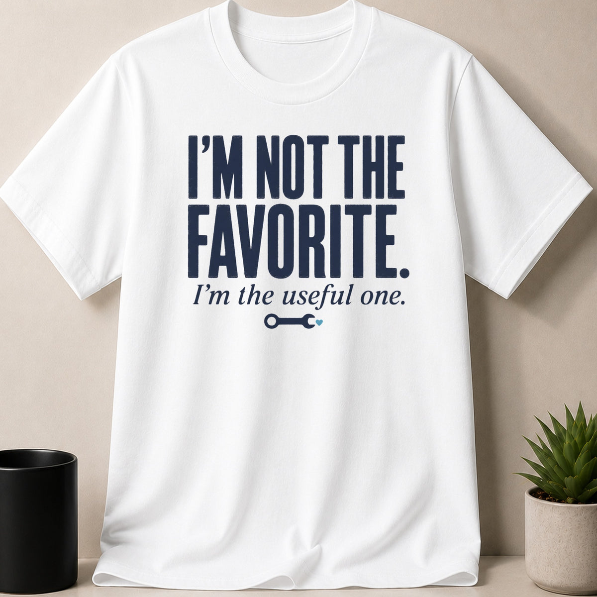 White t-shirt with navy text reading "I'M NOT THE FAVORITE. I'm the useful one."