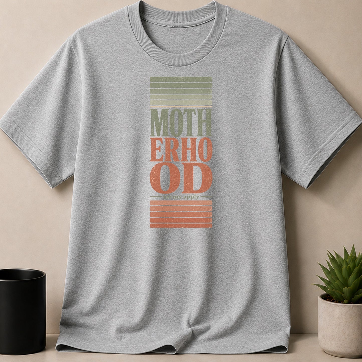 Grey t-shirt with "MOTHERHOOD" text and "terms apply" below.