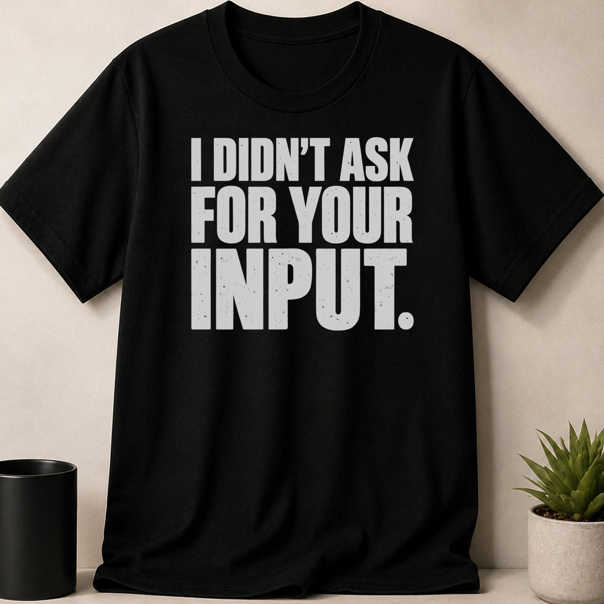 A black crewneck t-shirt featuring the white distressed text I DIDN'T ASK FOR YOUR INPUT.