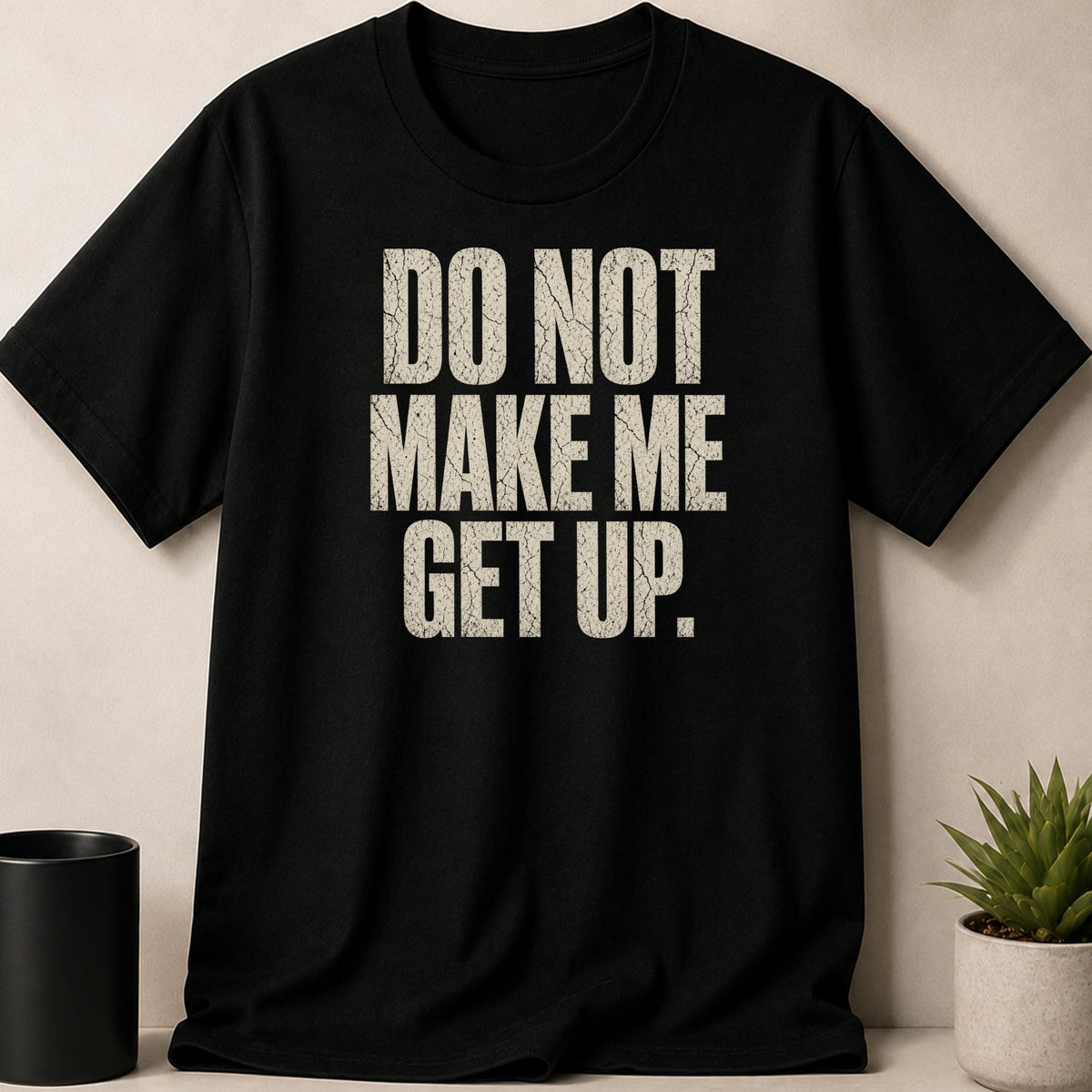 Black t-shirt with "DO NOT MAKE ME GET UP" text in distressed white lettering.