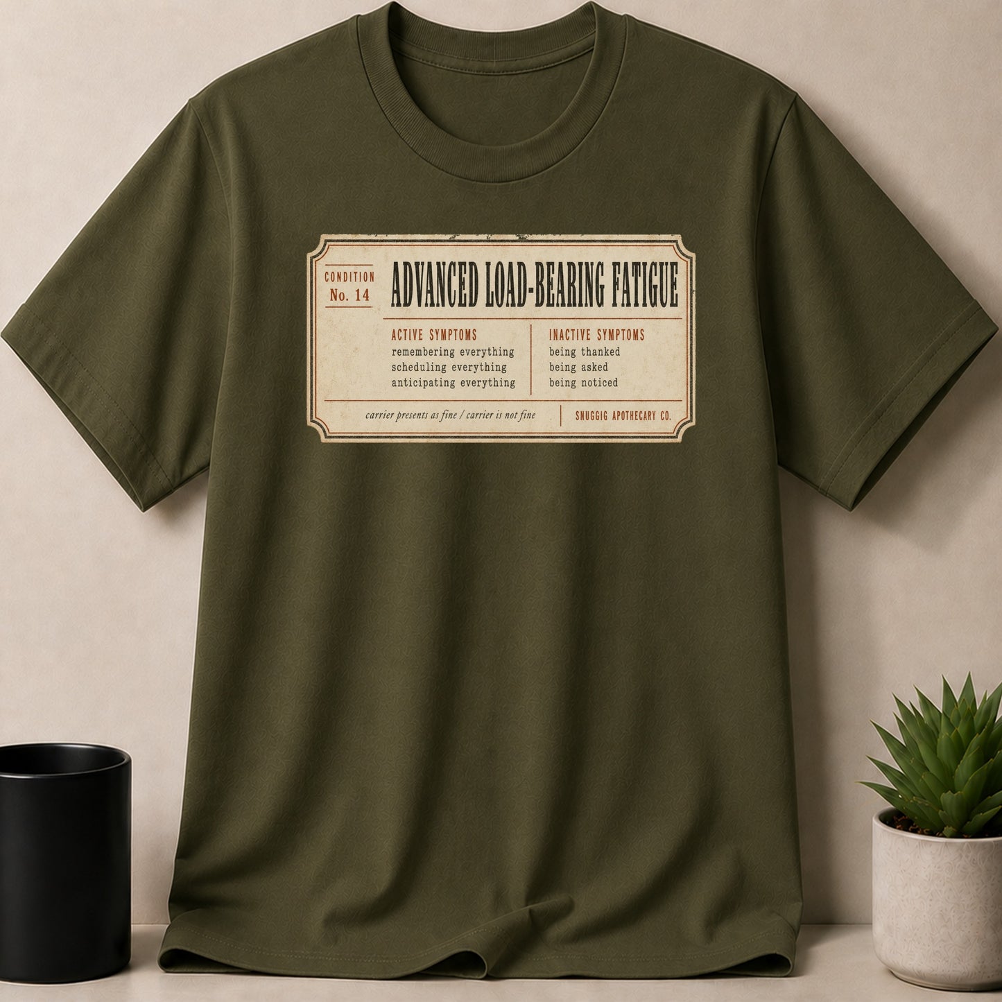 Olive green t-shirt with "Advanced Load-Bearing Fatigue" print and symptom list.