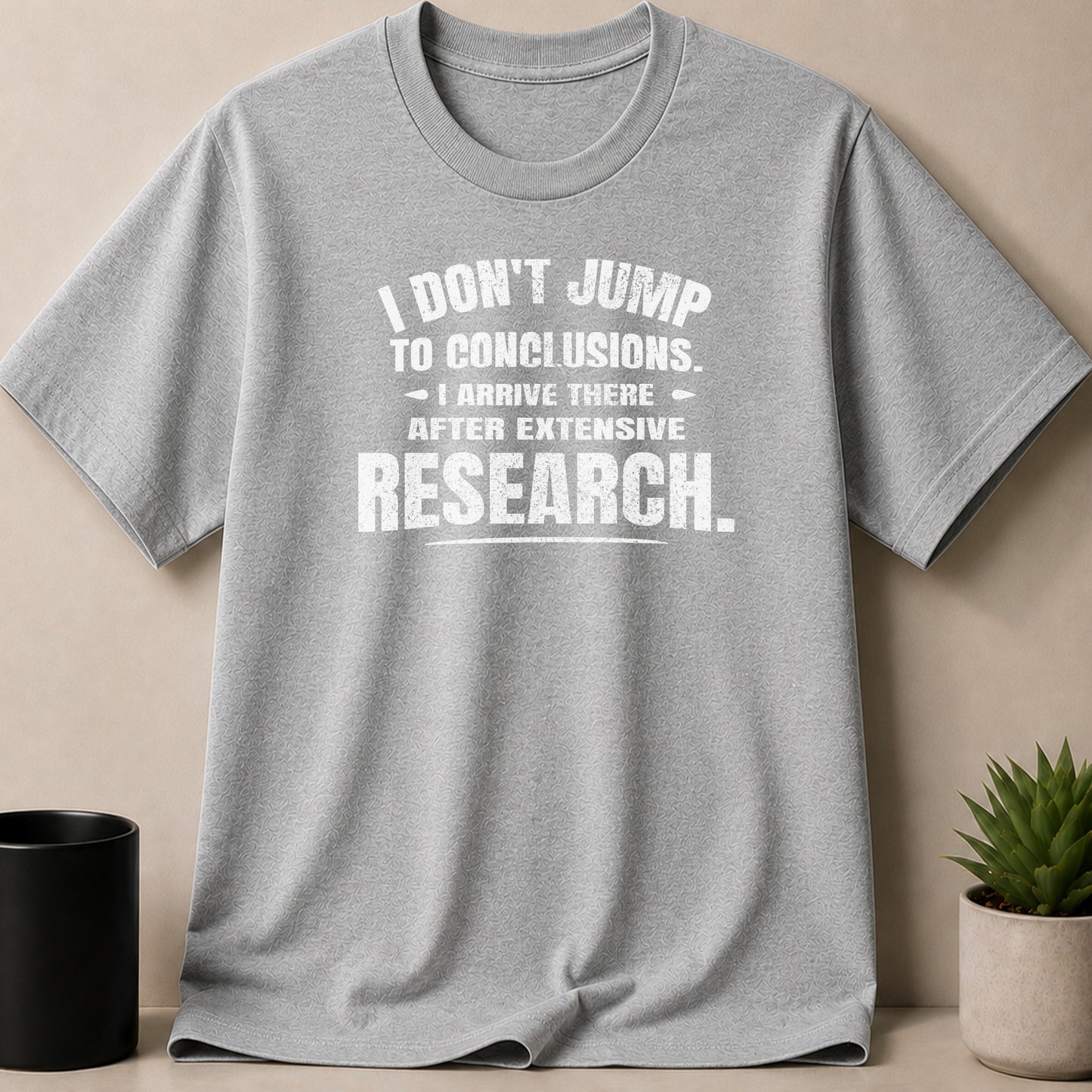 Grey t-shirt with white text: "I don't jump to conclusions. I arrive there after extensive research."