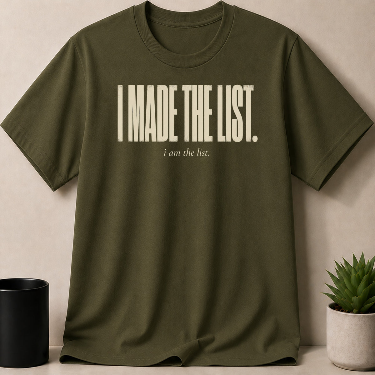 Olive green t-shirt with cream text "I MADE THE LIST. i am the list."