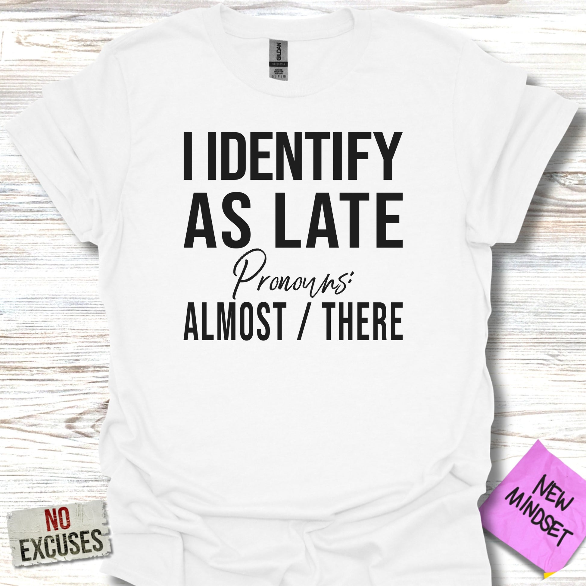 White t-shirt with "I identify as late Pronouns: Almost / There" text.