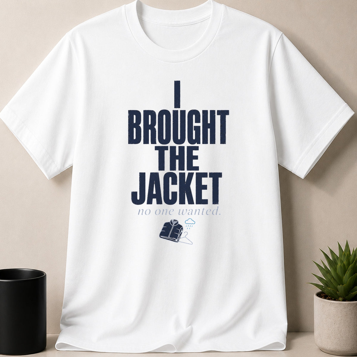 White t-shirt with navy text "I BROUGHT THE JACKET no one wanted." and jacket graphic.