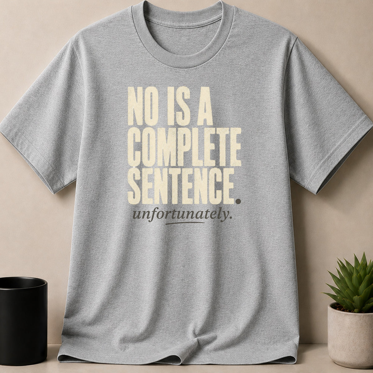 Grey t-shirt with cream text "NO IS A COMPLETE SENTENCE. unfortunately."