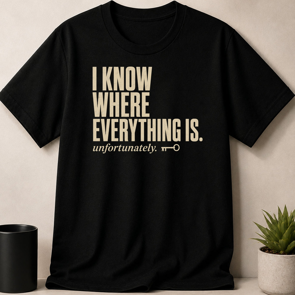 Black t-shirt with text "I KNOW WHERE EVERYTHING IS. unfortunately." and a key symbol.