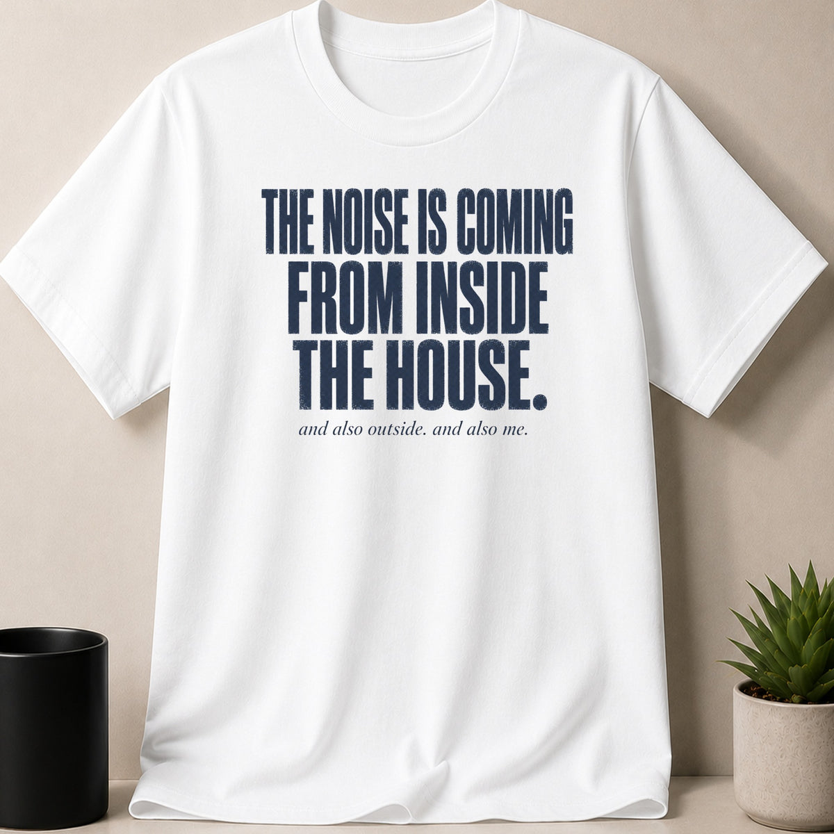 White t-shirt with navy text: "THE NOISE IS COMING FROM INSIDE THE HOUSE." and also outside. and also me.