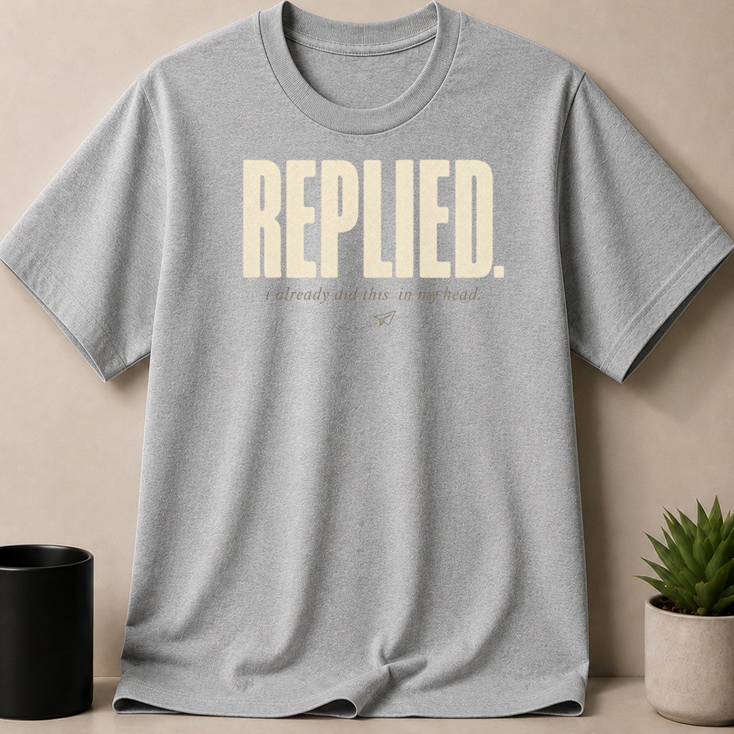 Grey t-shirt with "REPLIED. i already did this in my head." text and paper airplane graphic.