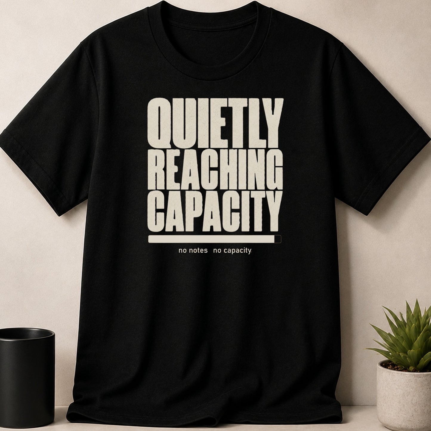 Black t-shirt with "QUIETLY REACHING CAPACITY" and a loading bar.