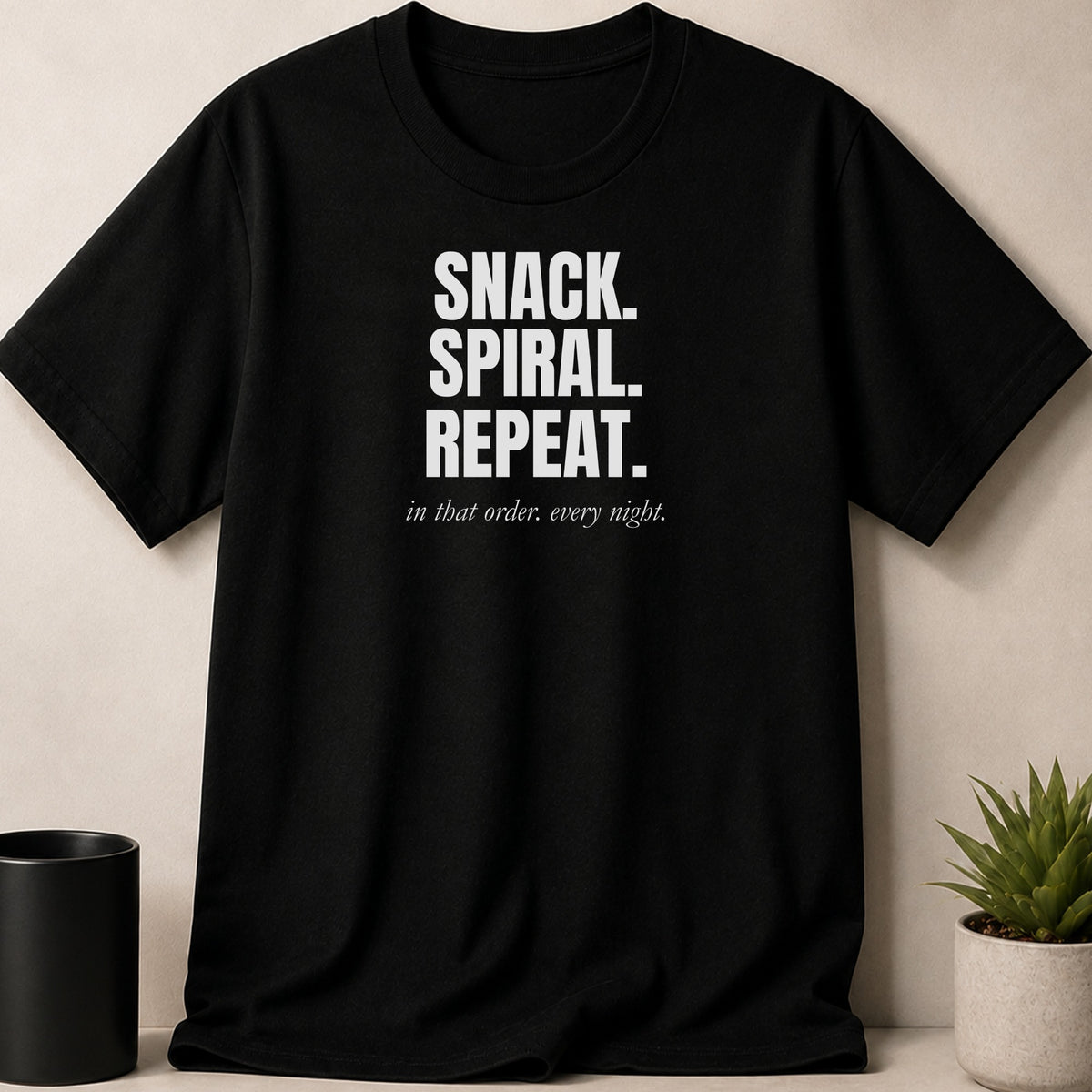 Black t-shirt with white text: SNACK. SPIRAL. REPEAT. in that order. every night.