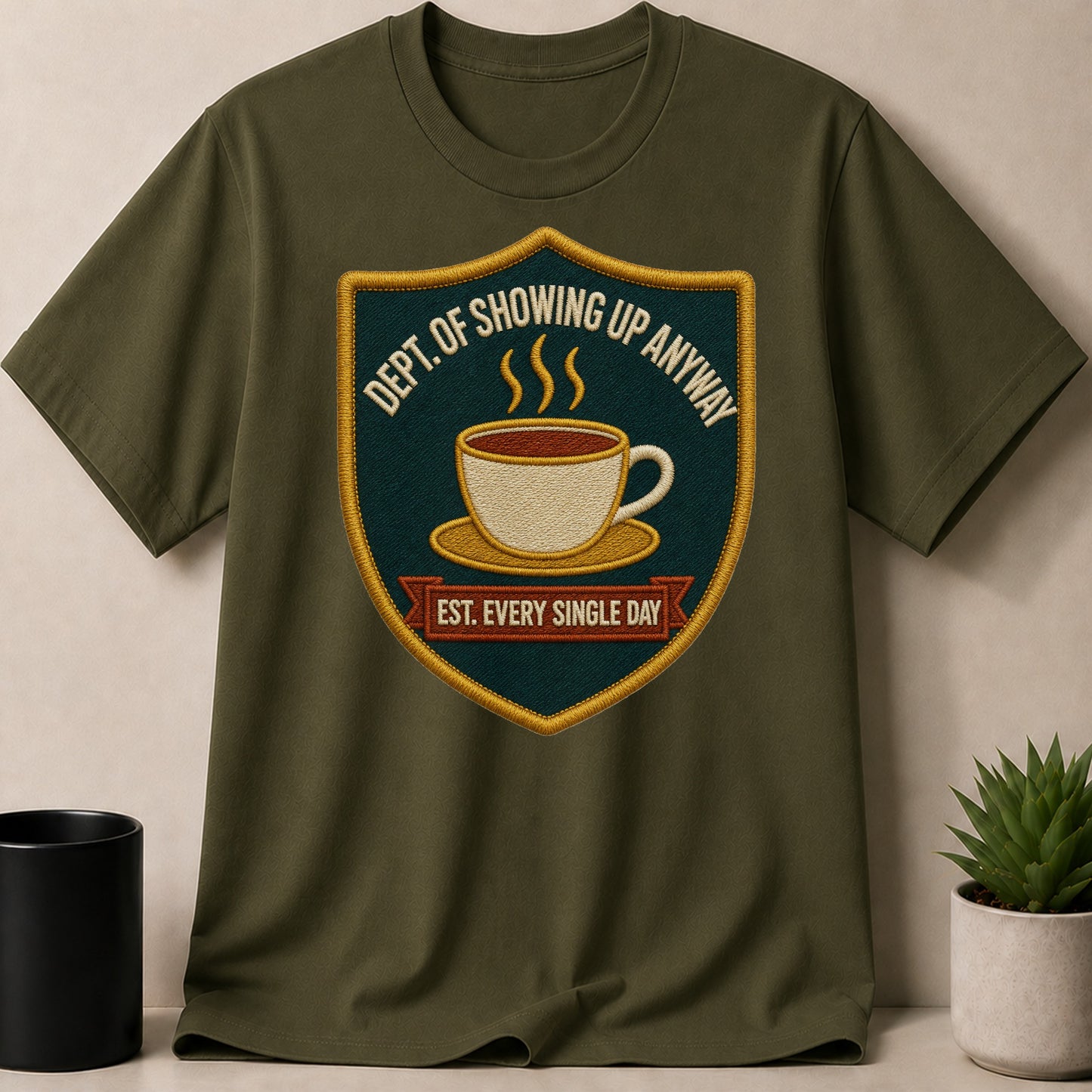 Olive green t-shirt with embroidered patch featuring a coffee cup and text.