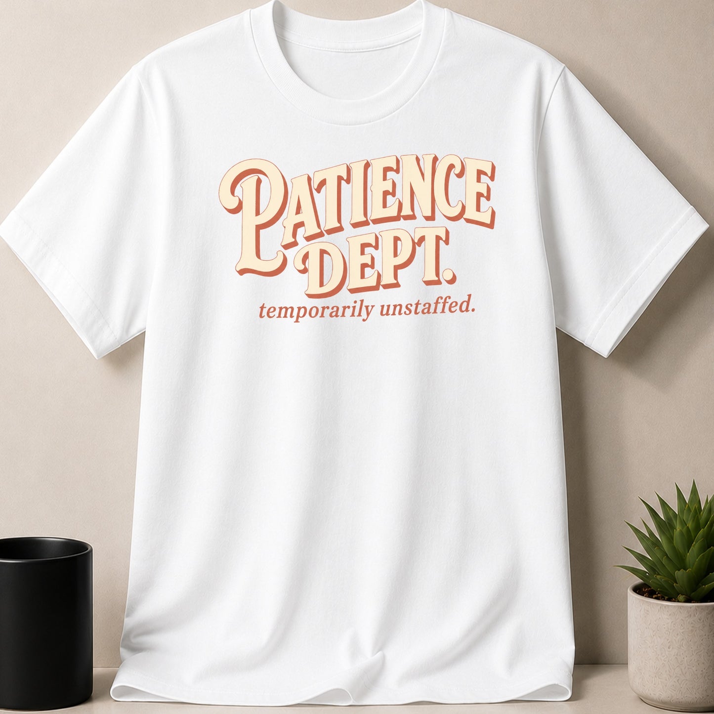 White t-shirt with "Patience Dept. temporarily unstaffed." graphic.