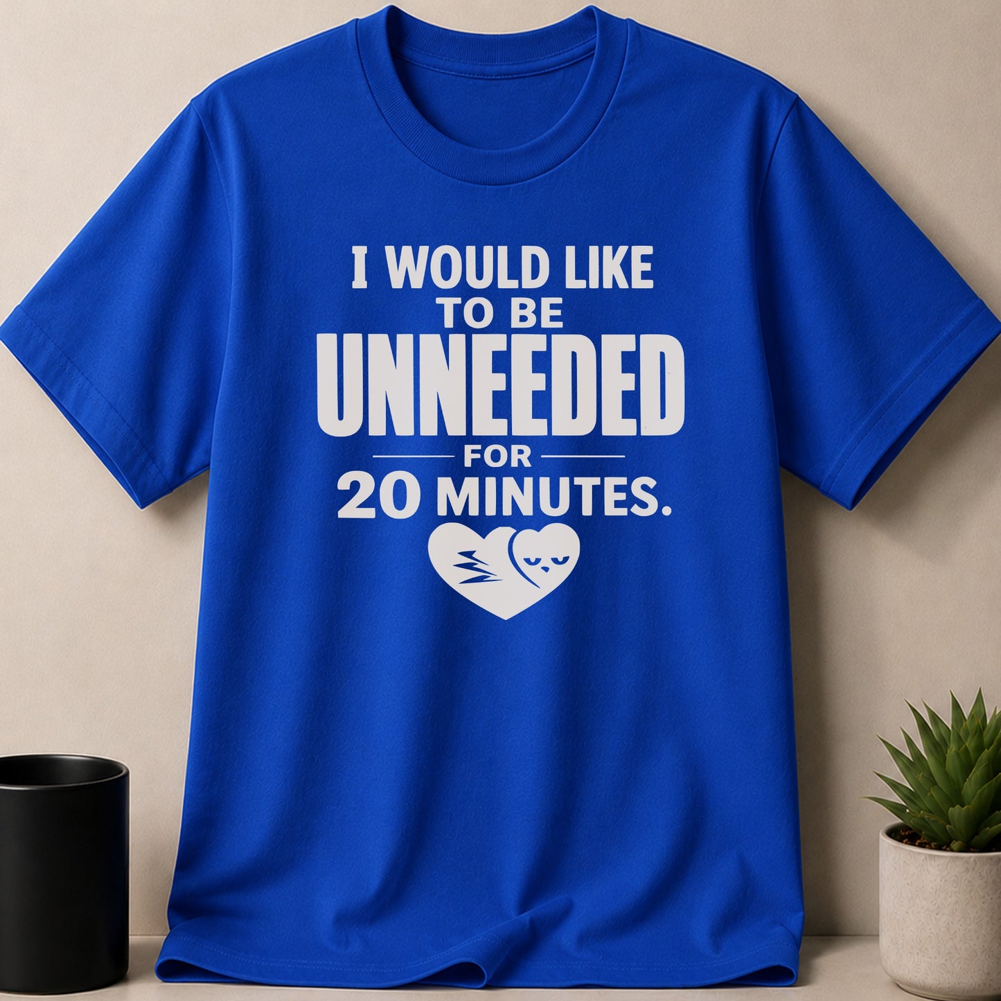 Blue t-shirt with white text "I WOULD LIKE TO BE UNNEEDED FOR 20 MINUTES." and a heart graphic.