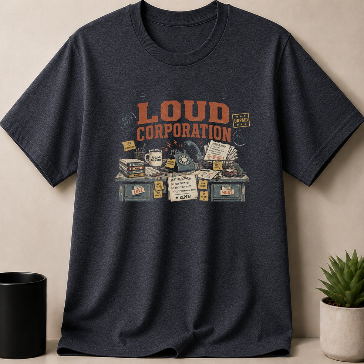 Dark Heather t-shirt — T-shirt graphic: "Loud Corporation" with a cluttered desk featuring daily objectives.