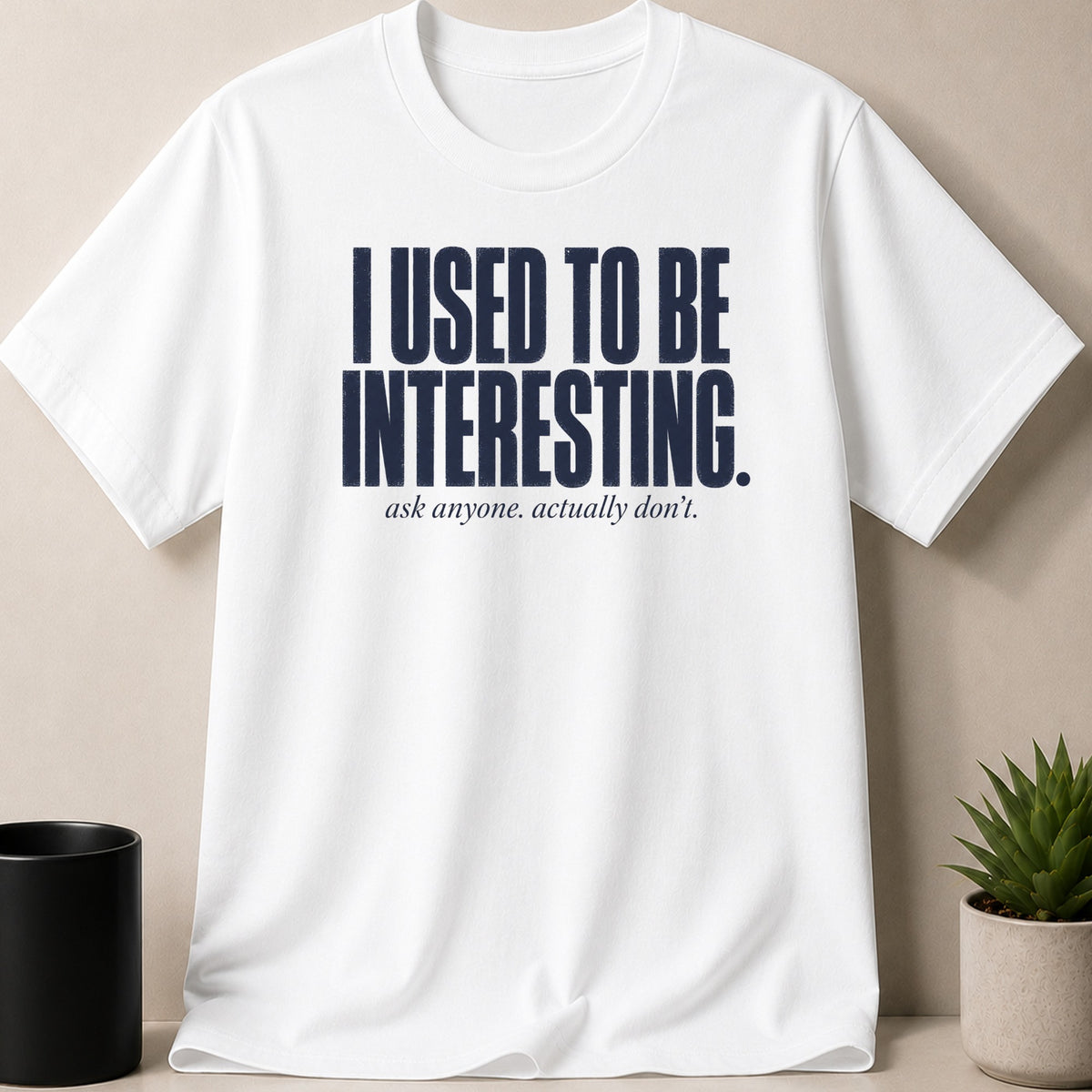 White t-shirt with navy text: "I USED TO BE INTERESTING. ask anyone. actually don't."
