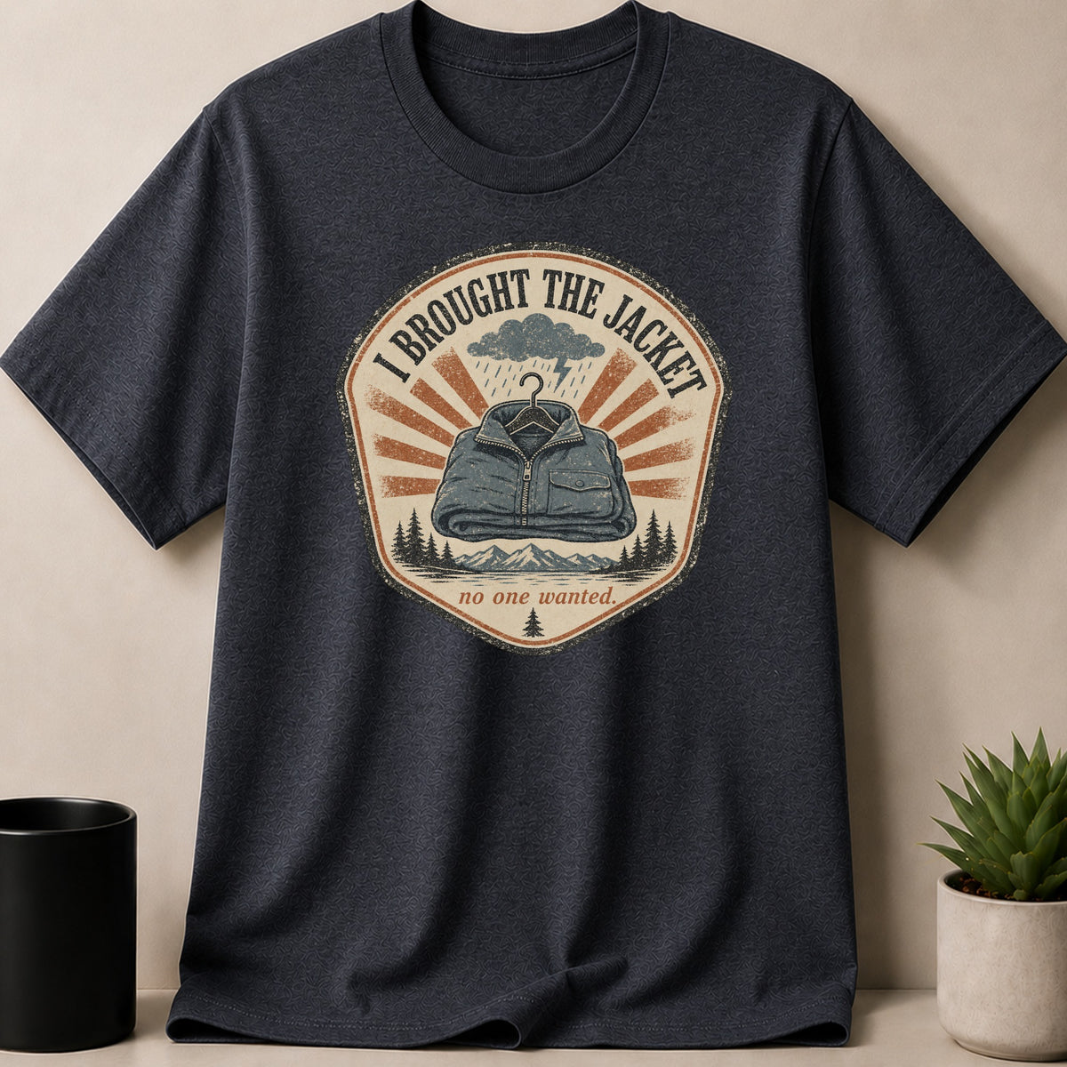 Dark grey t-shirt with graphic: "I BROUGHT THE JACKET no one wanted."