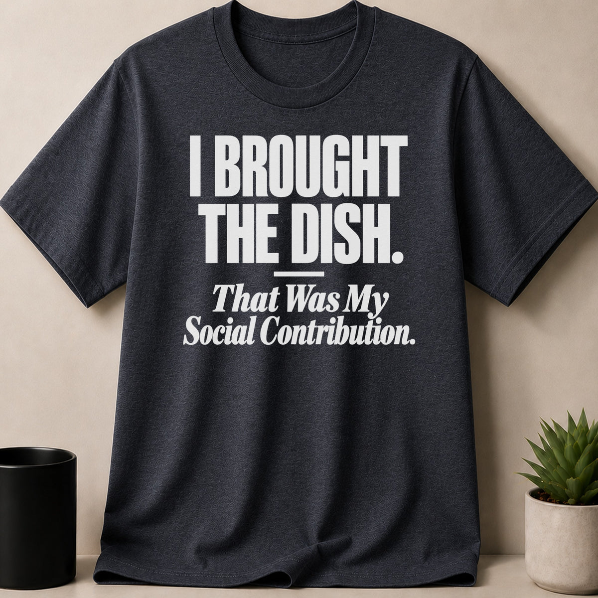 Dark grey crewneck t-shirt featuring the white text I BROUGHT THE DISH. That Was My Social Contribution.