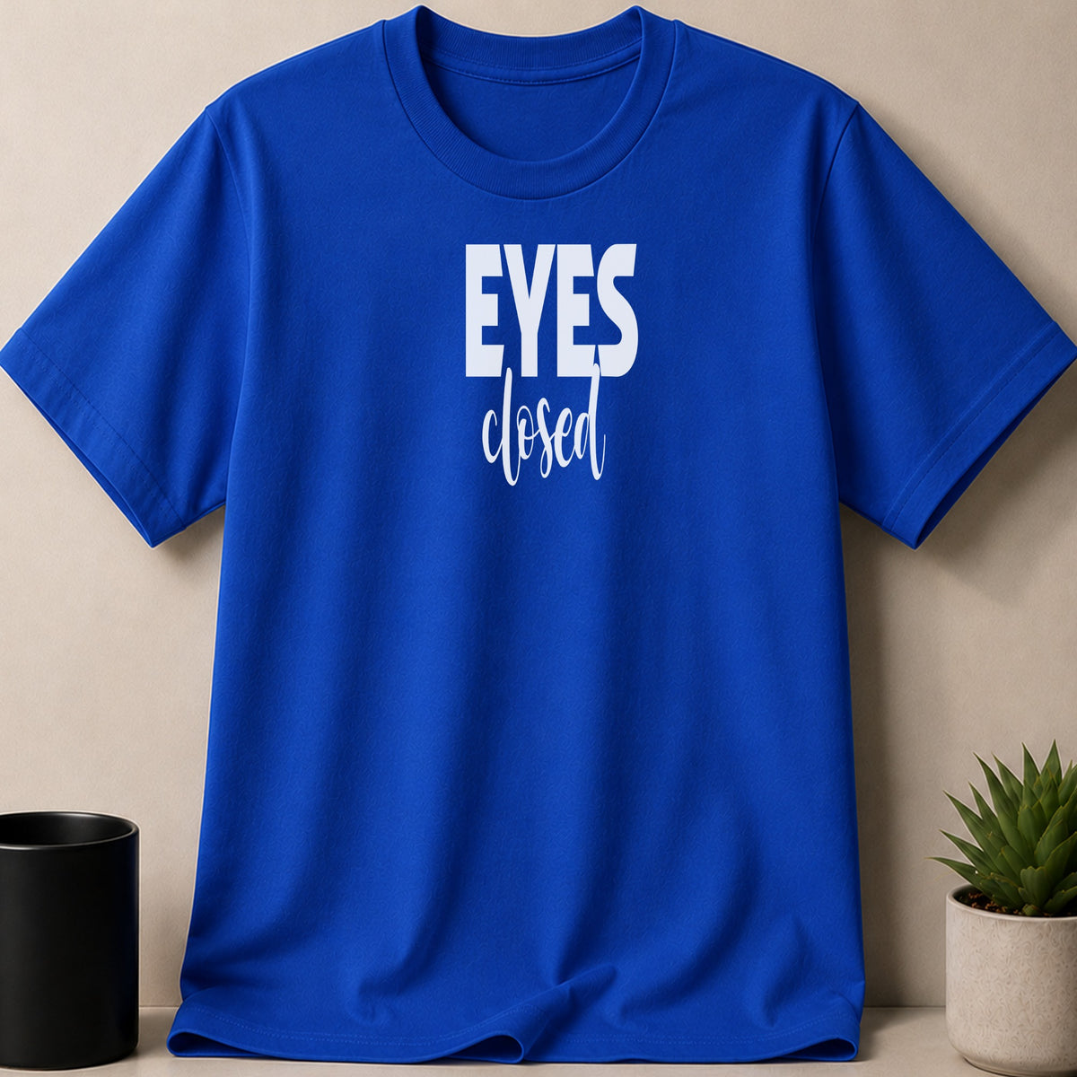 Blue t-shirt with white text reading "EYES closed" on the front.