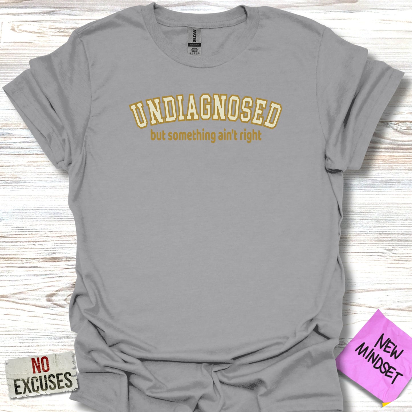 Grey t-shirt with "UNDIAGNOSED but something ain't right" in yellow text.