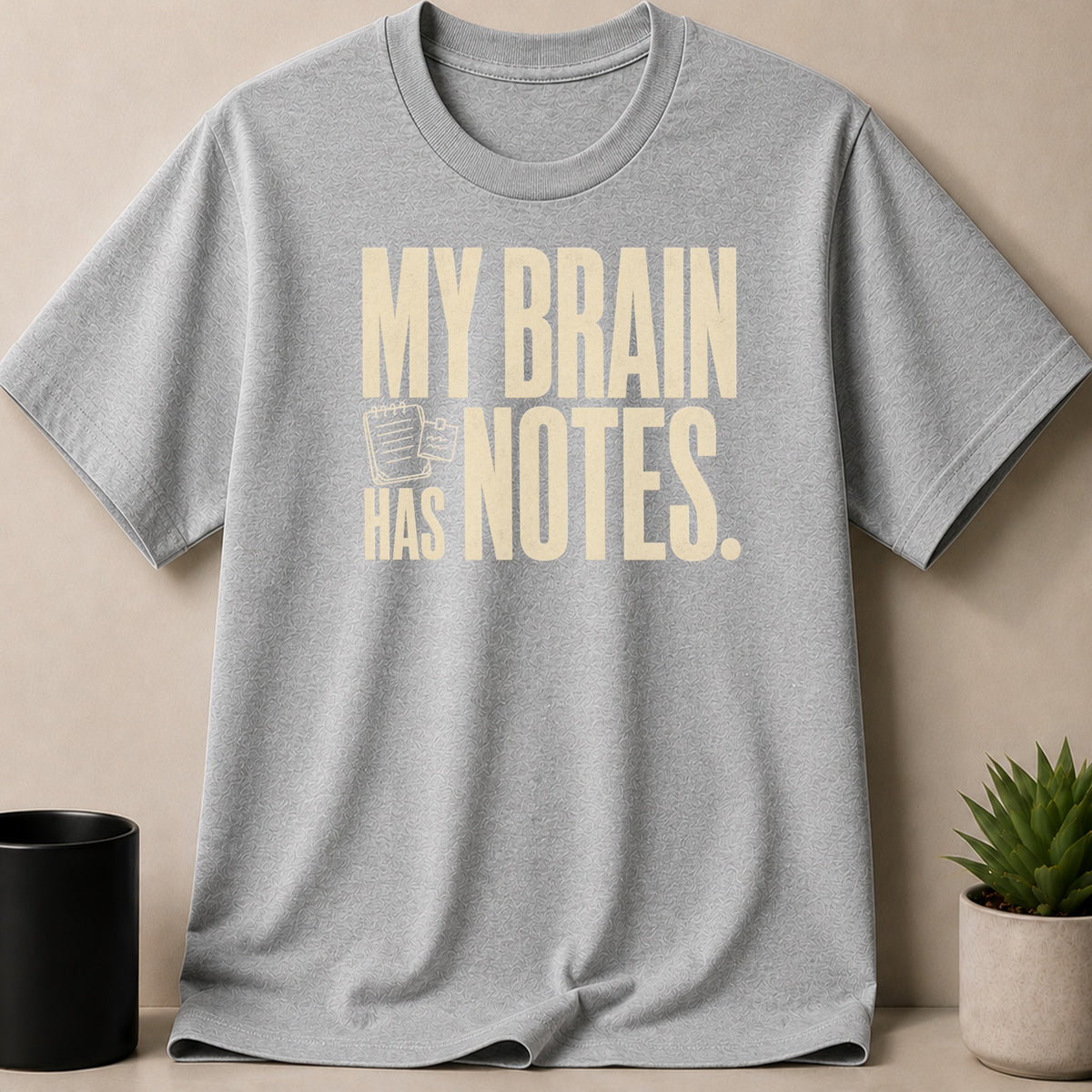Grey t-shirt with "MY BRAIN HAS NOTES." printed in cream.