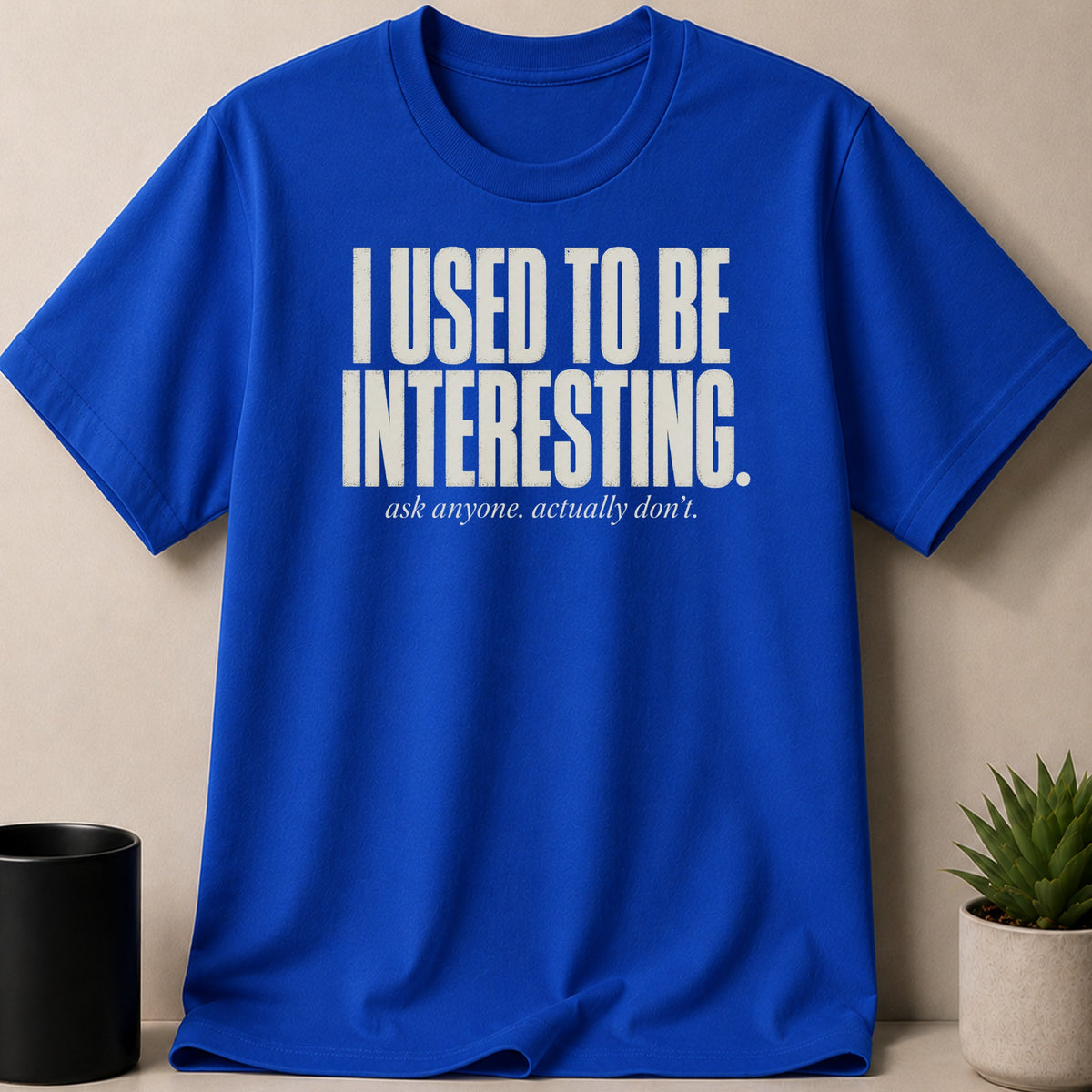 Blue t-shirt with white text that reads "I USED TO BE INTERESTING. ask anyone. actually don't."